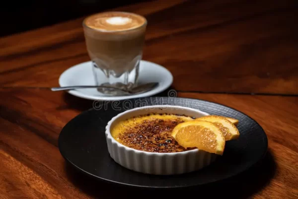 creme brulee burnt cream orange coffee cappuccino dark wood table french vanilla dessert caramelised sugar top white 196921246